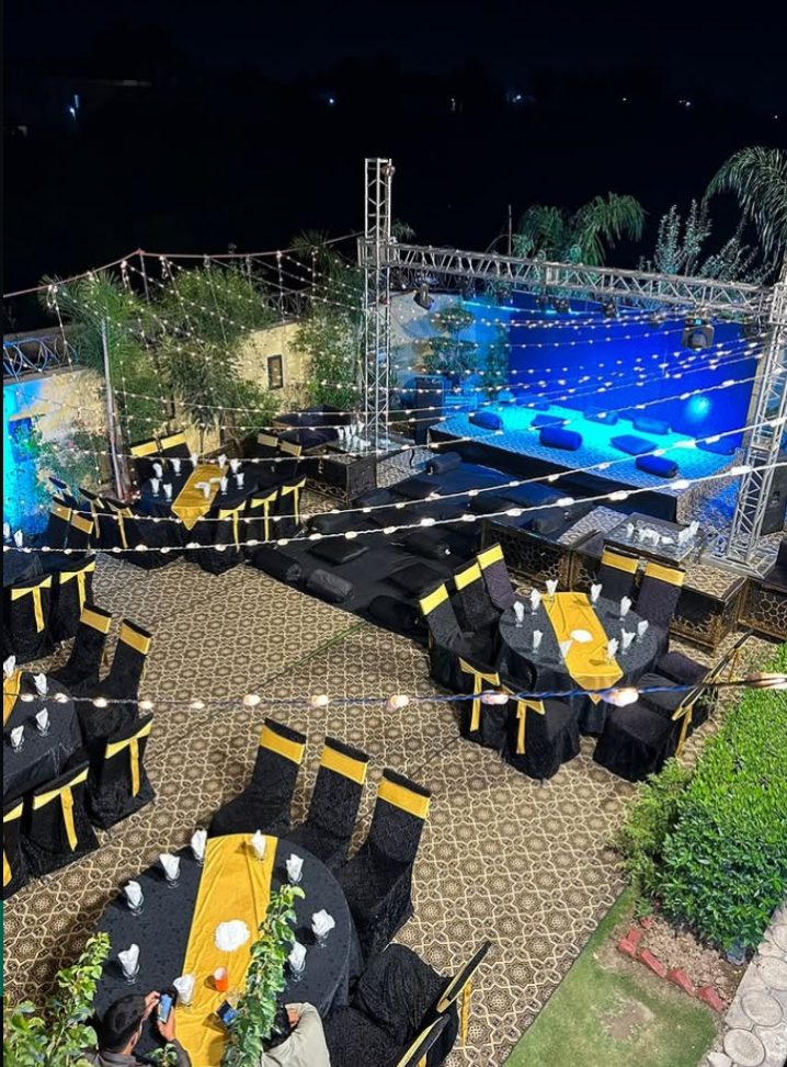 Oasis rooftop event setup with stage and dressed tables